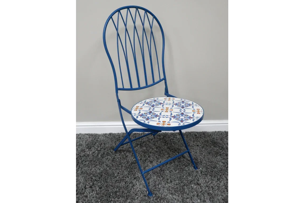 Blue metal folding chair with patterned ceramic seat on grey carpet