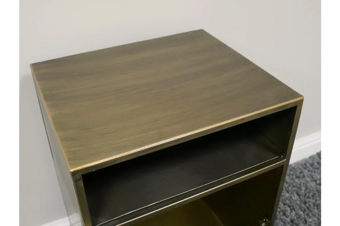 Close view of bronze metal bedside table with open shelf and textured finish