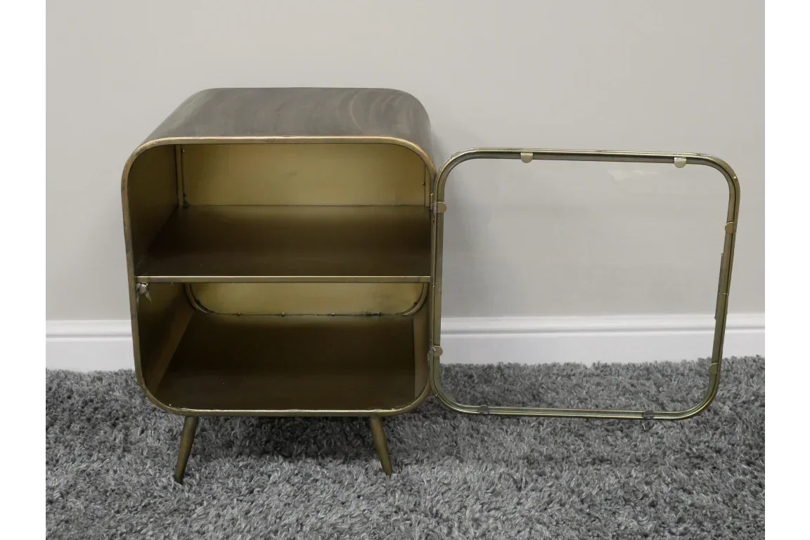 Gold metal side table with open door, internal shelf, and rounded corners on grey carpet