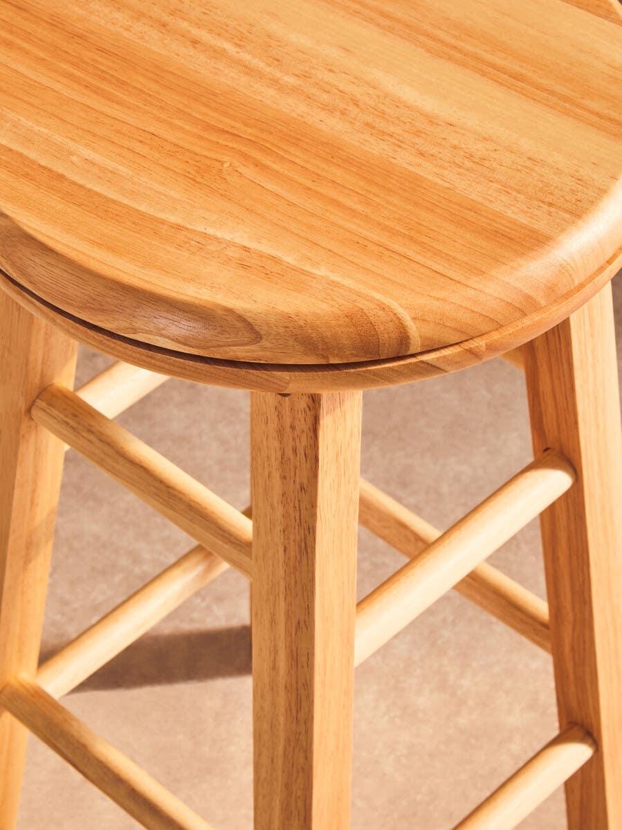Natural wood bar stool with round seat and sturdy legs, close-up angle