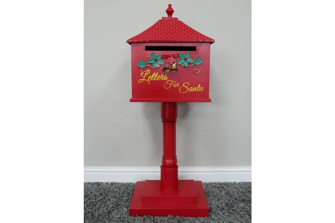 Red metal Santa letter box with decorative holly and gold script on a pedestal stand