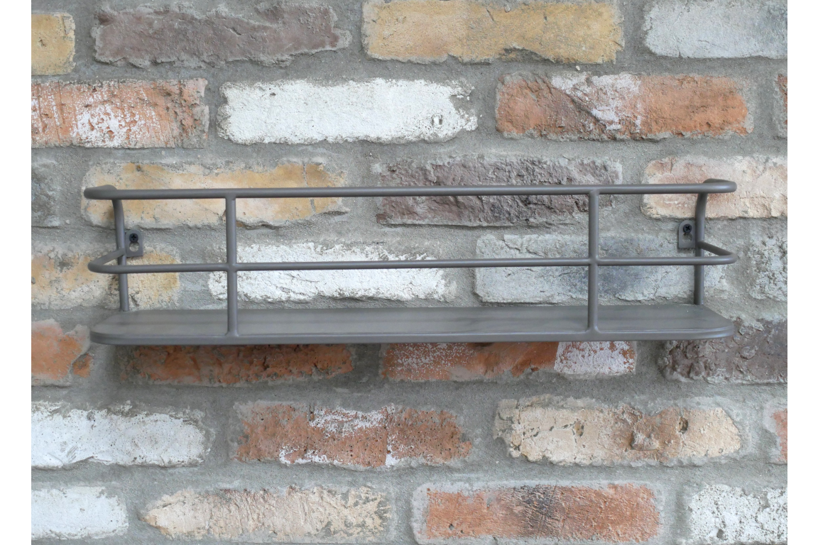 Grey metal wall-mounted shelf with raised rails, displayed against a rustic multicolored brick wall.