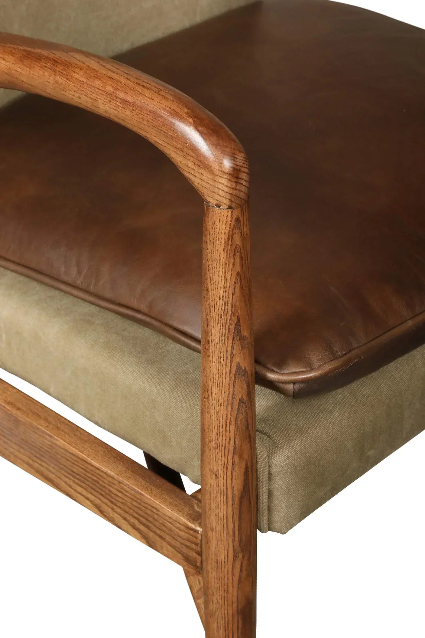 Brown leather seat cushion on wooden armchair with green fabric base, close up view