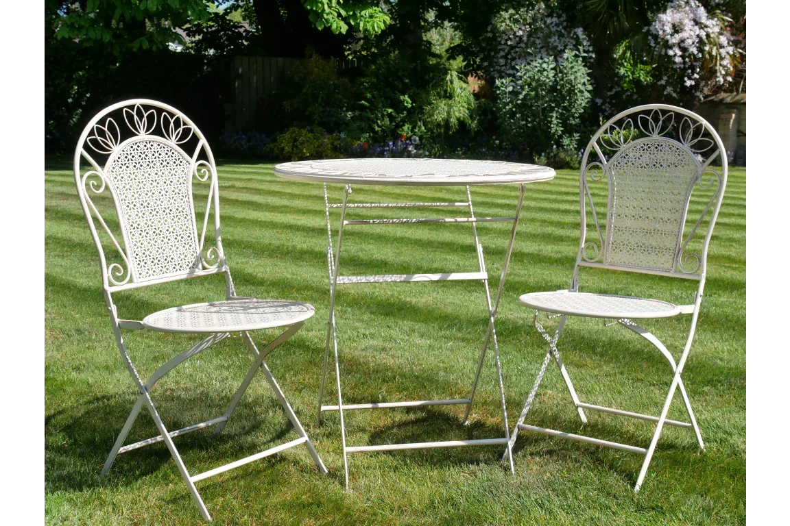 White metal garden bistro set with two chairs and round table on lawn