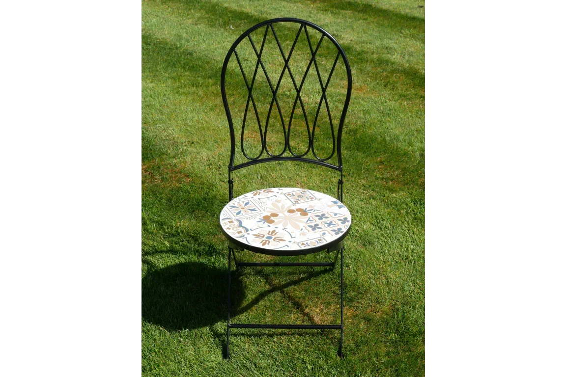 Metal garden chair with patterned mosaic seat on grass