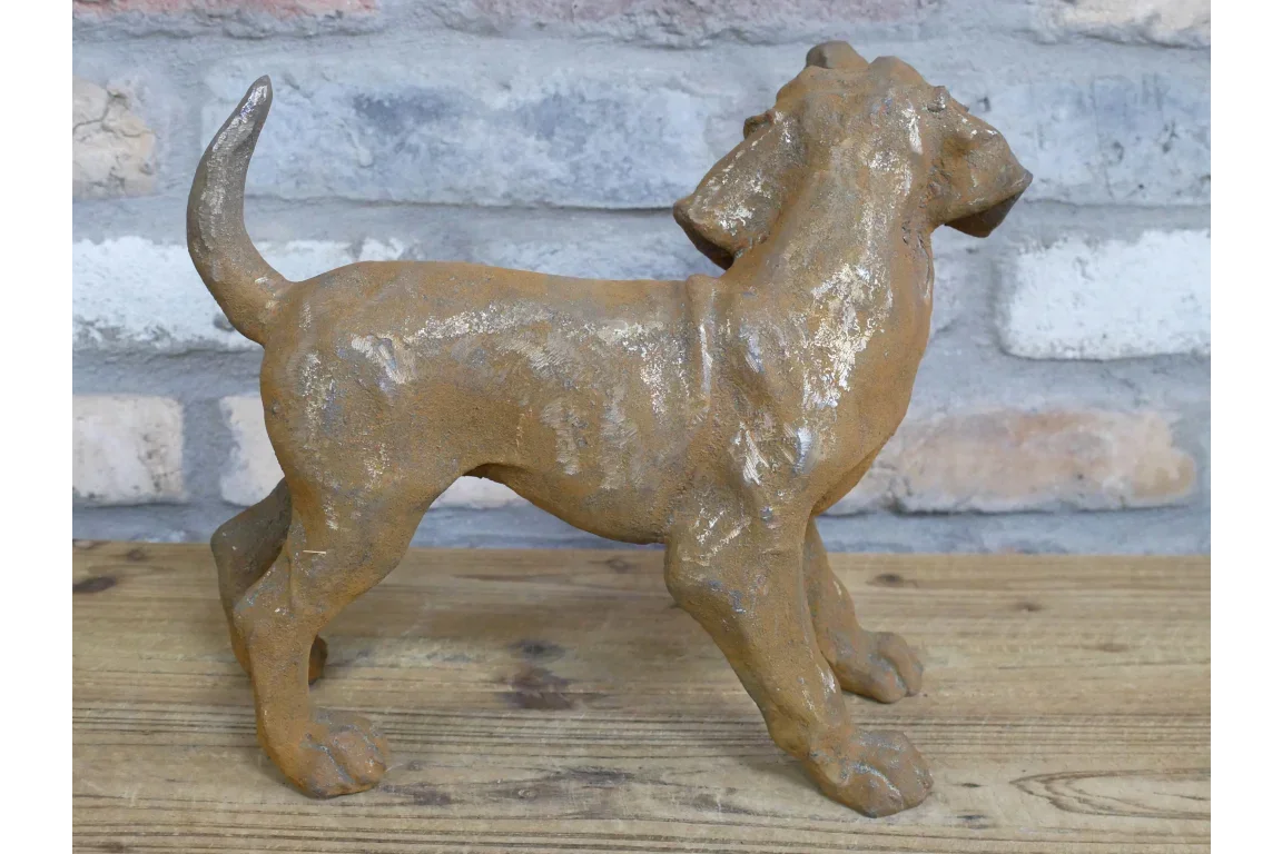 Rust effect metal dog ornament on wooden surface with brick background