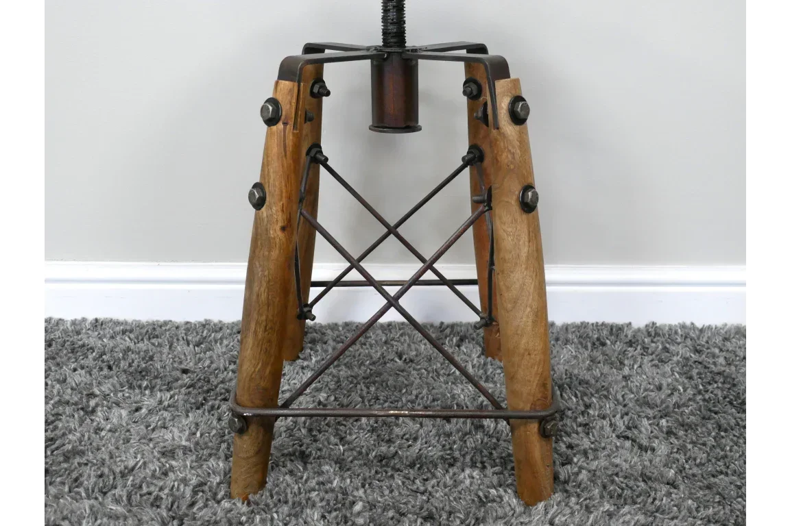 Industrial stool base with wooden legs and metal cross supports on grey carpet