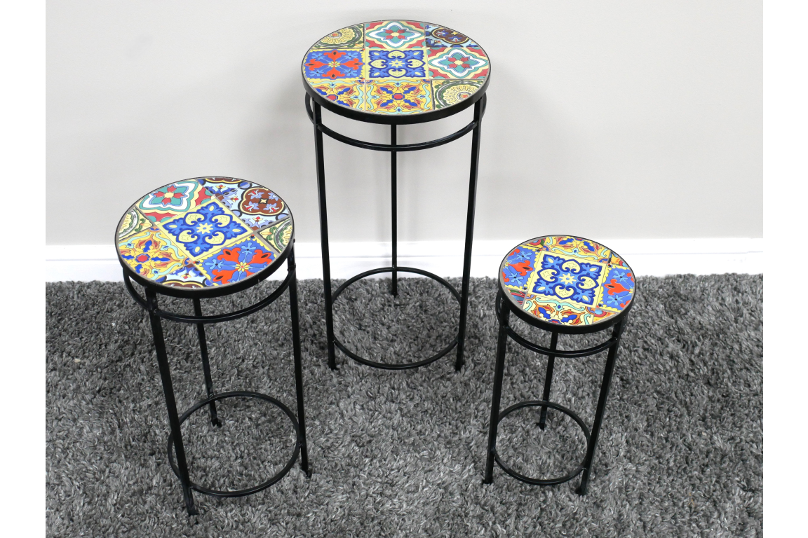 Set of 3 round side tables with black metal legs and colorful patterned ceramic tile tops on gray carpet.