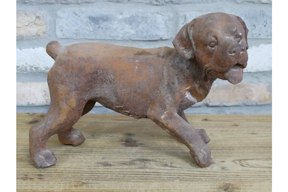 Rustic cast iron dog ornament on wooden surface with brick wall background