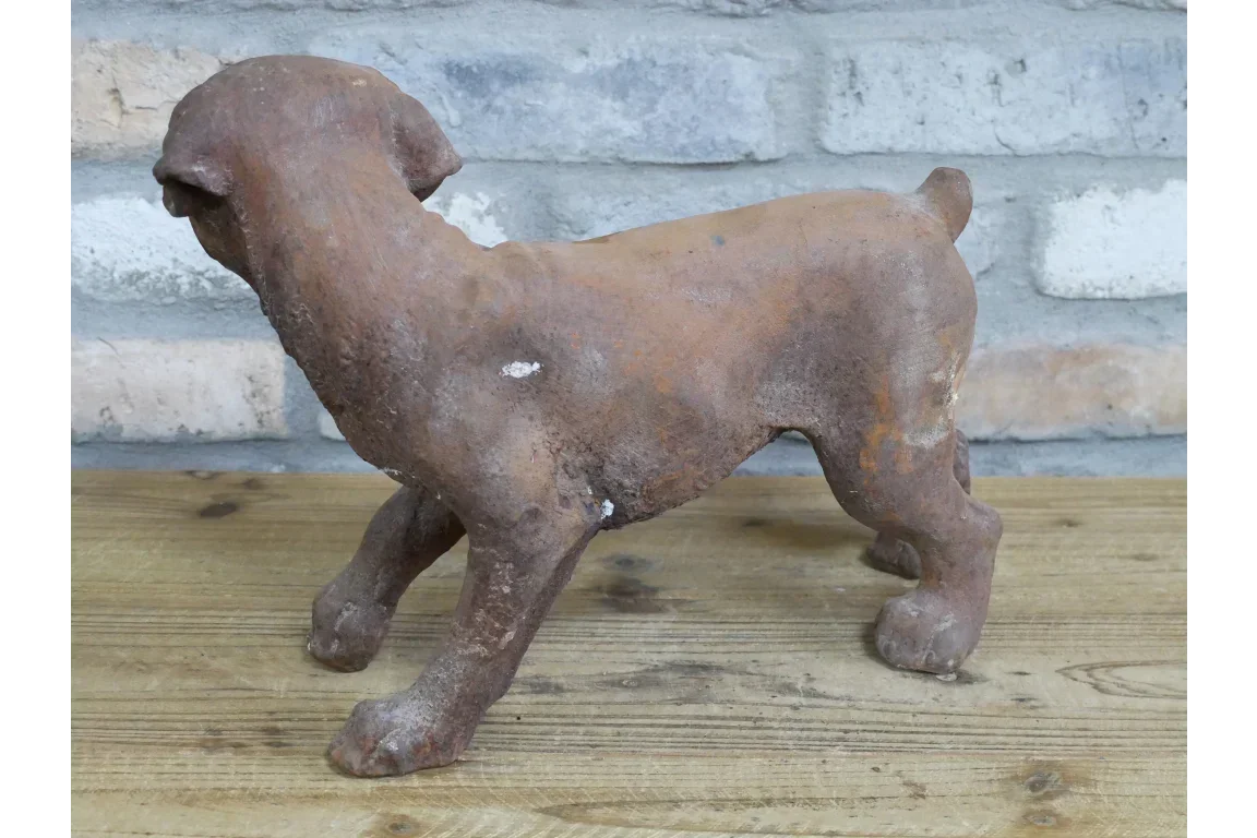 Rustic cast iron dog ornament on wooden surface with brick wall background