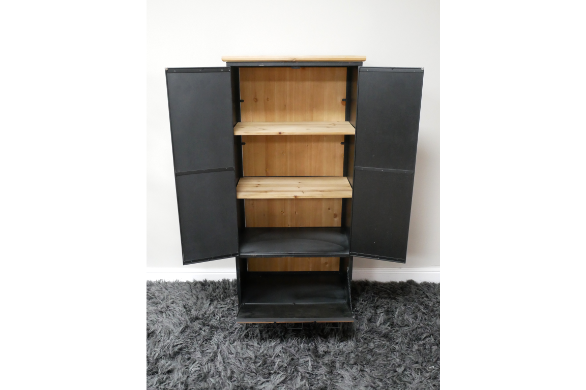 Black metal storage cabinet with light wood shelves, open doors, standing on gray carpet against white wall.
