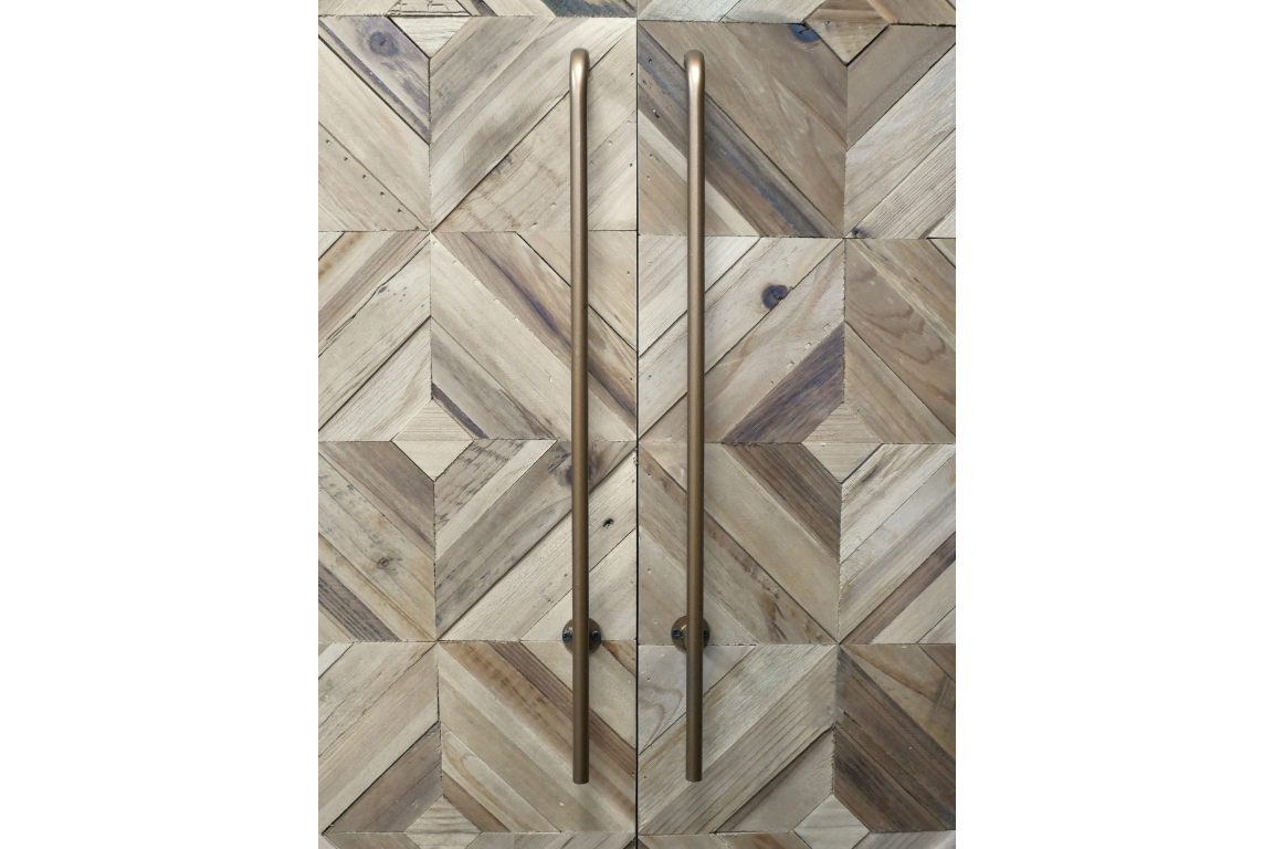 Wine cabinet with geometric patterned wood doors in natural tones and tall bronze handles, front view.