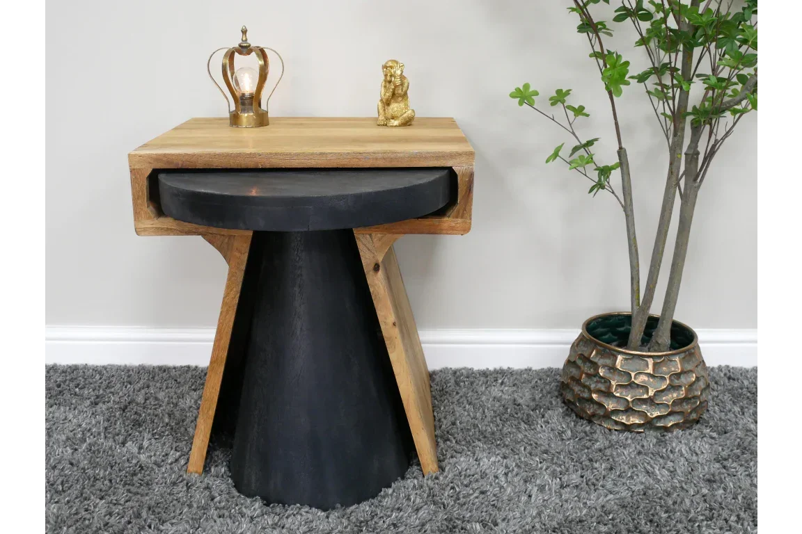 Modern wooden side table with black base, lamp and figurine, on grey carpet near potted plant
