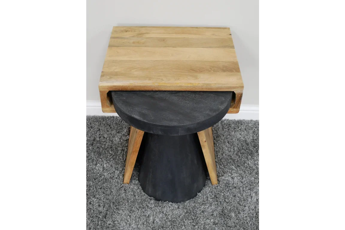 Modern wooden side table with black round base on grey carpet
