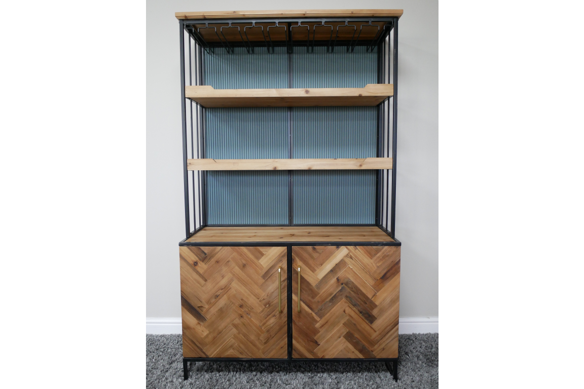 Bar cabinet with light wood shelves, herringbone wood doors, black metal frame, angled front view on grey carpet