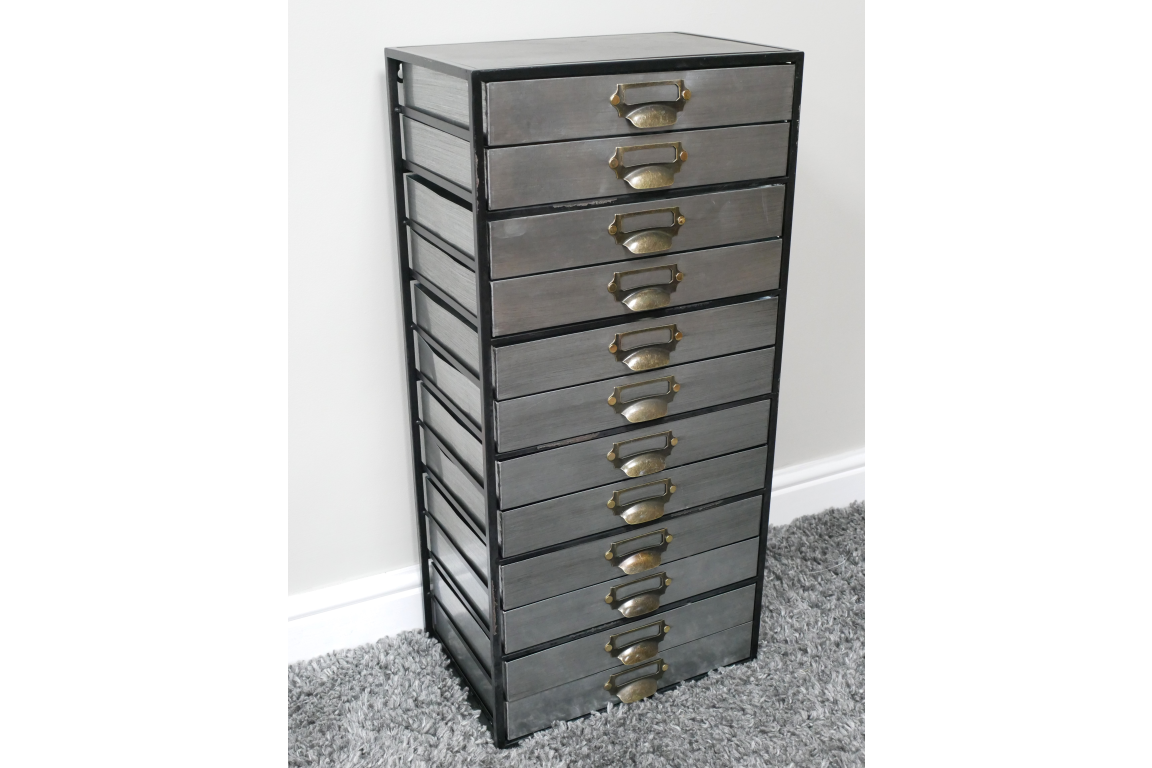 Tall industrial drawer cabinet with ten gray metal drawers and brass handles, side angled view on carpeted floor.