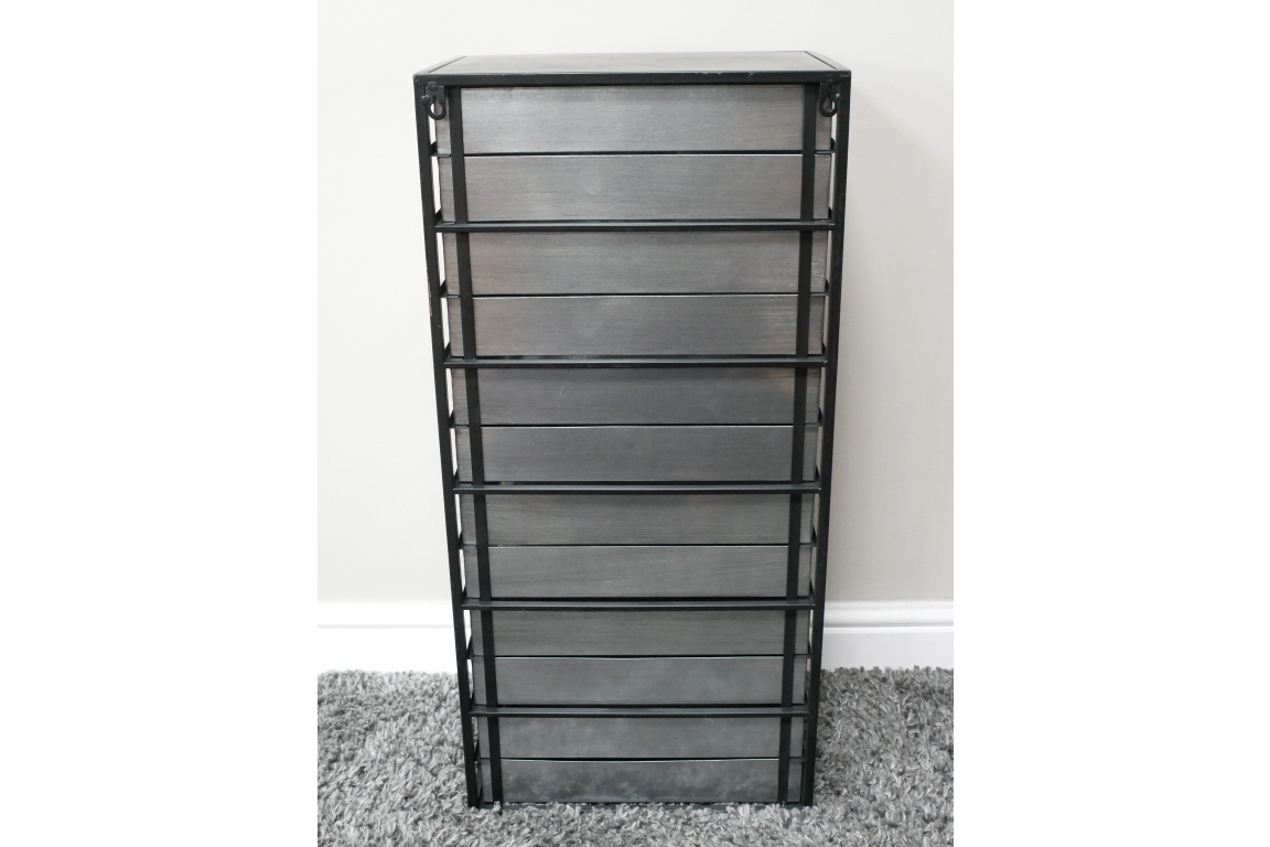 Tall industrial drawer cabinet with gray wooden panels and black metal frame, standing on a gray carpet.