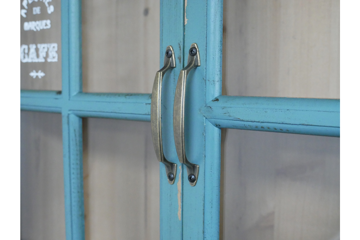 Close-up of blue painted wooden wall unit doors with metal handles and glass panels.
