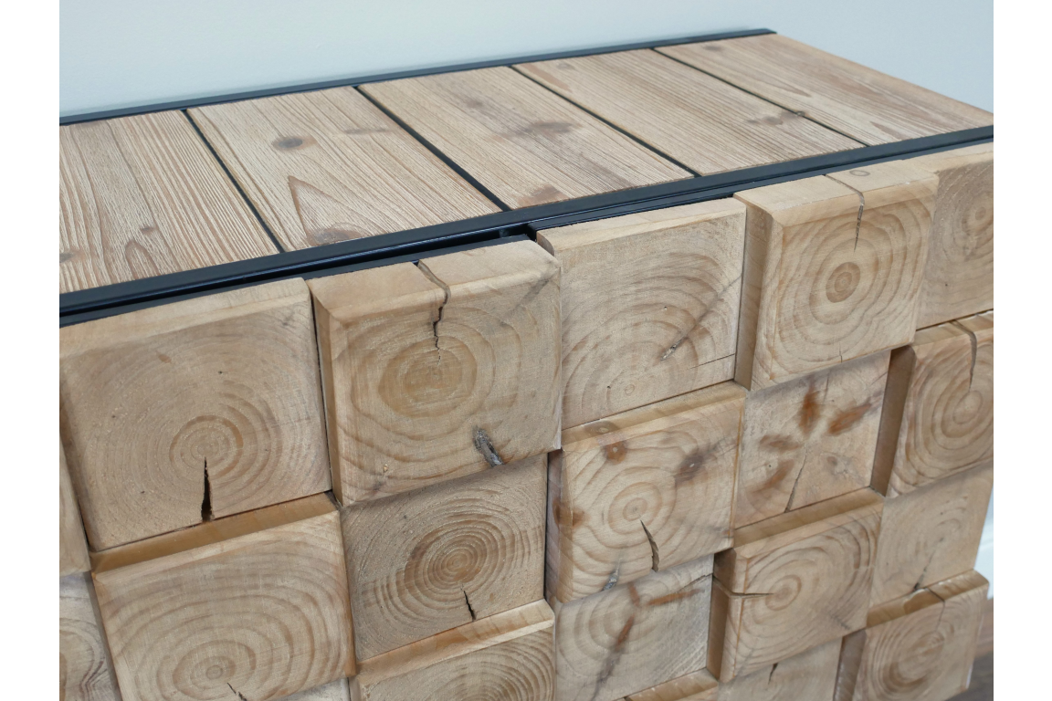 Chunky wooden cabinet with natural wood grain and knots, front angled view, metal top edges, light wood finish.