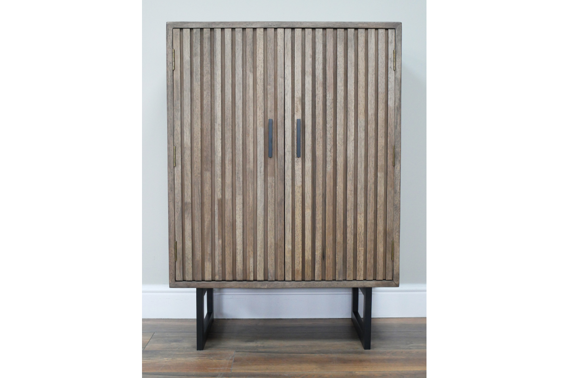 Two-door slatted wood cabinet in natural brown finish with black metal base, front view against white wall.