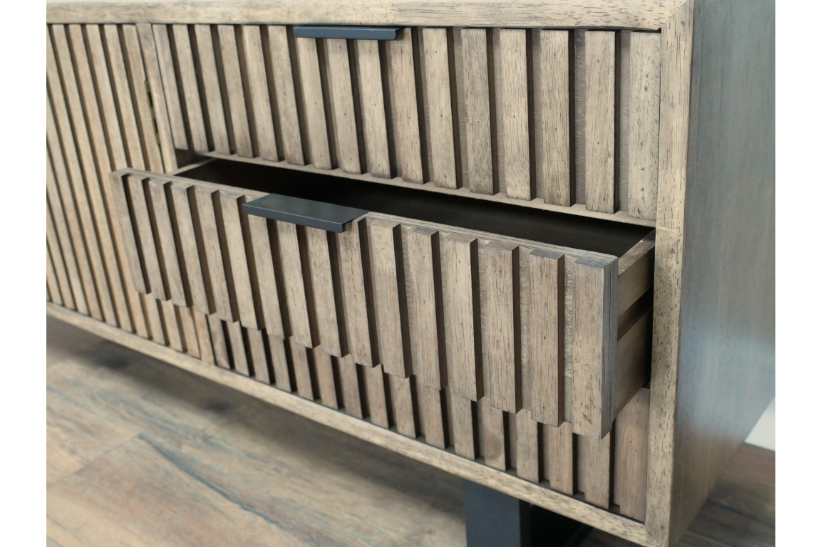 Wooden TV low sideboard slatted cabinet in light brown with black handle, open drawer detail, angled view.
