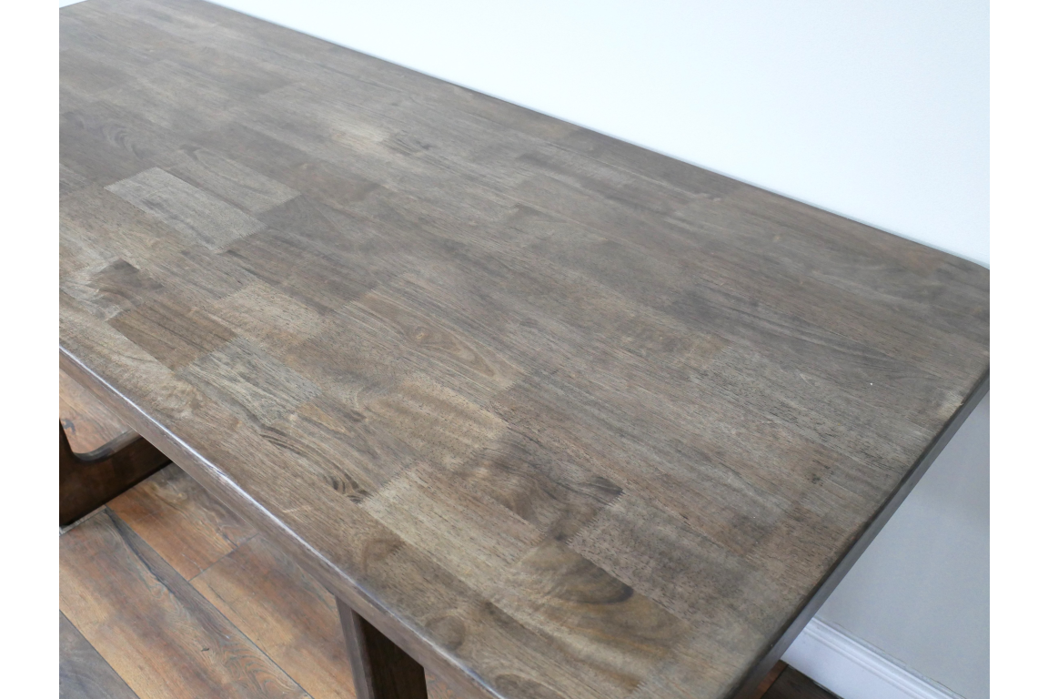 Rectangular wooden dining table with a smooth, dark grey-brown top, shown from a high angle in a room.