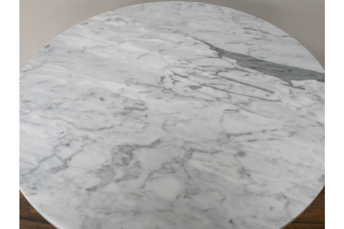 Round side table with white and gray marble top, angled close-up showing smooth texture and veining.