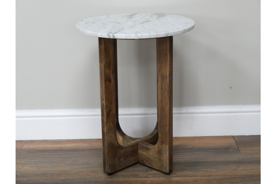 Small round side table with white marble top and dark brown wooden legs, shown from front angle on wood floor.