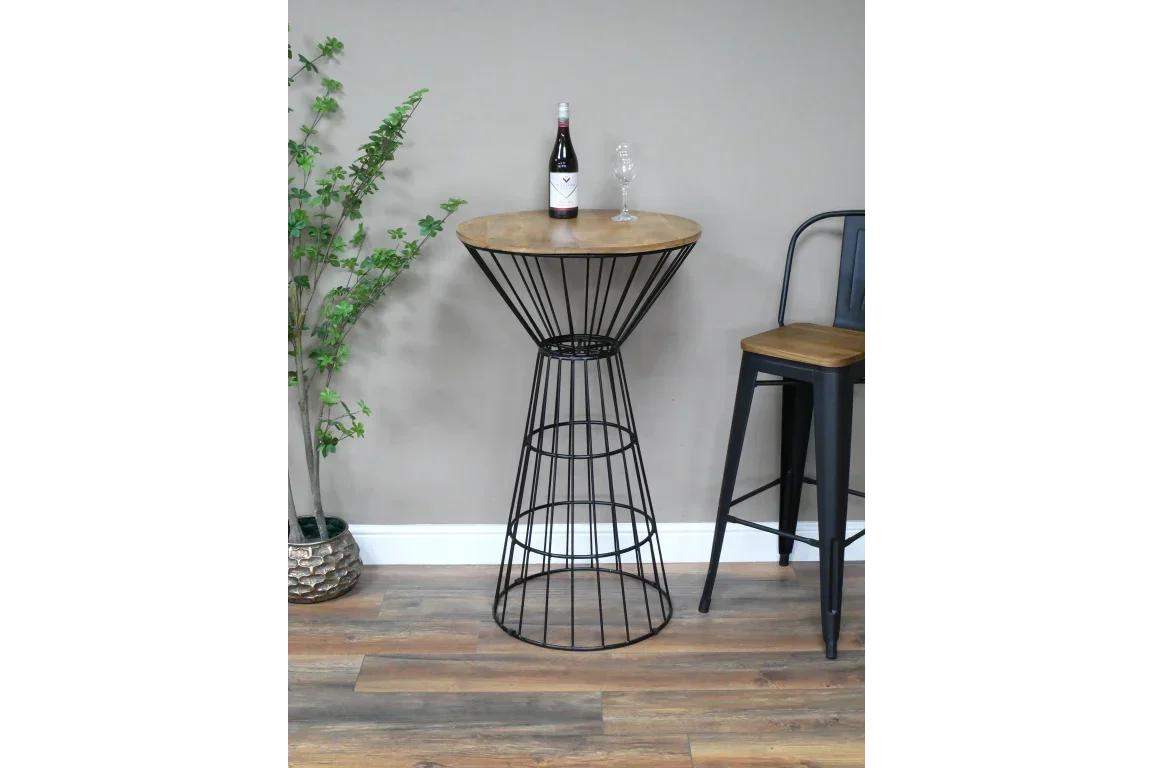Wood and black metal bar table with bottle and glass beside matching tall chair