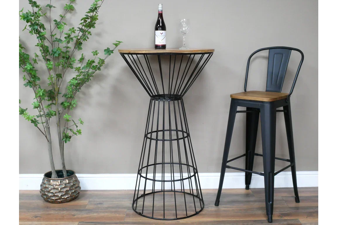 Industrial bar table with black metal frame and wood top next to matching bar stool