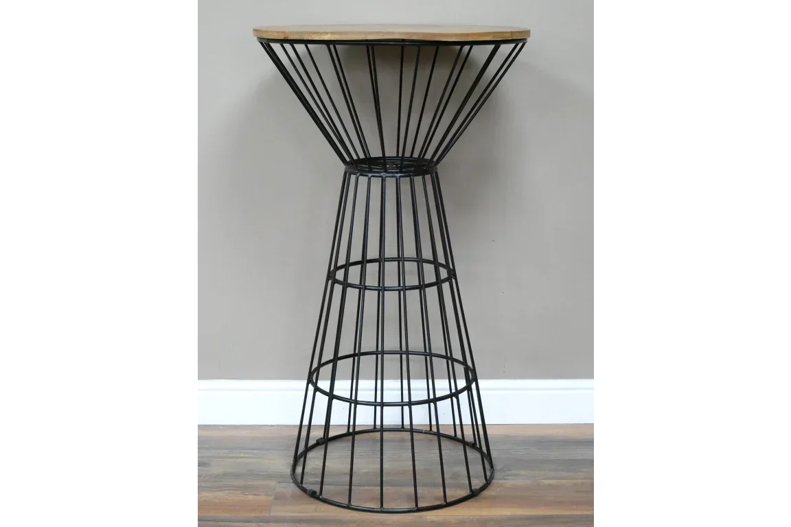 Industrial bar table with round wood top and black metal wire base against neutral wall