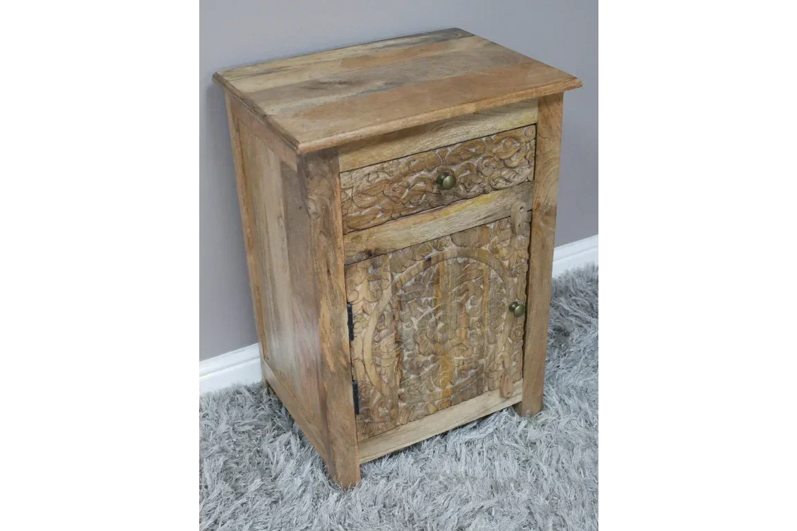 Mango wood bedside cabinet with carved drawer and door on grey rug