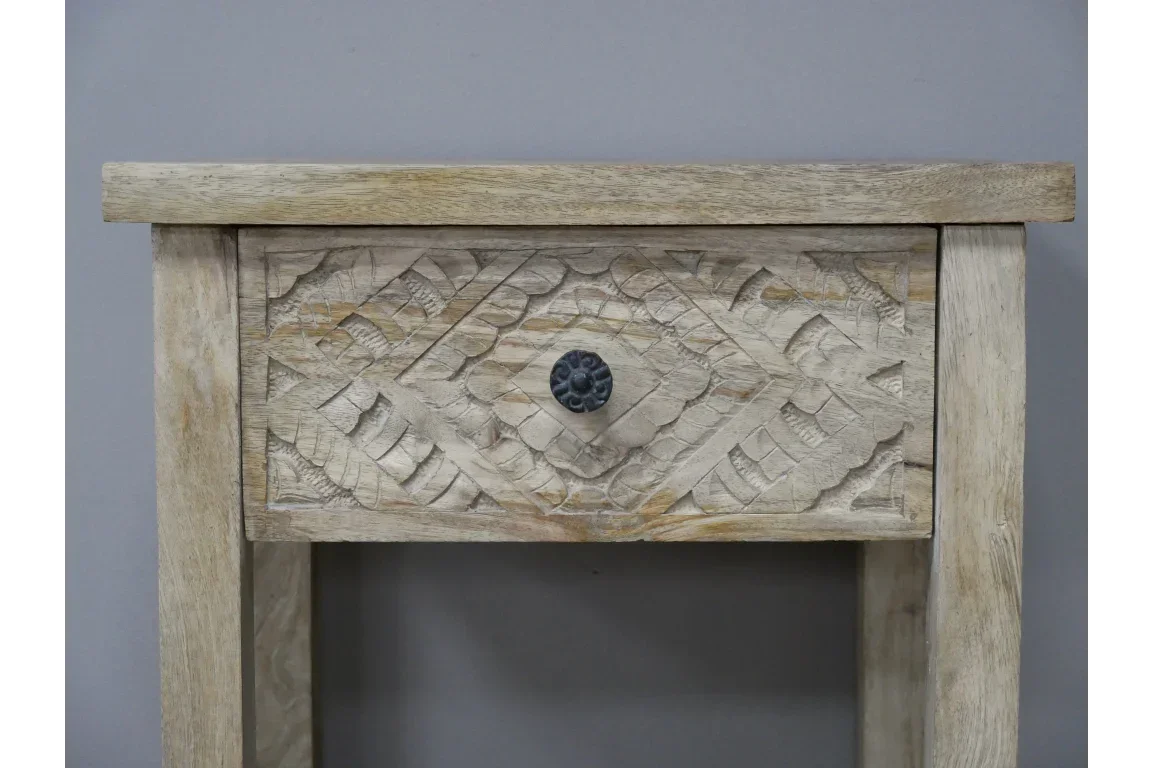 Carved wood bedside table with ornate drawer front and dark metal handle