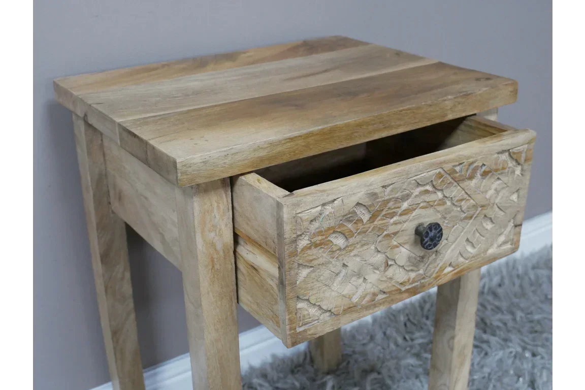 Light wood bedside table with single carved drawer and black knob, angled front view