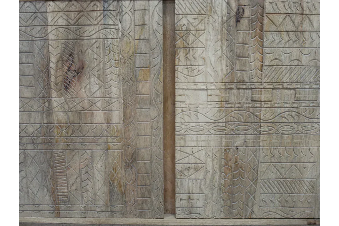 Close-up of carved wooden sideboard doors with geometric patterns and natural wood grain