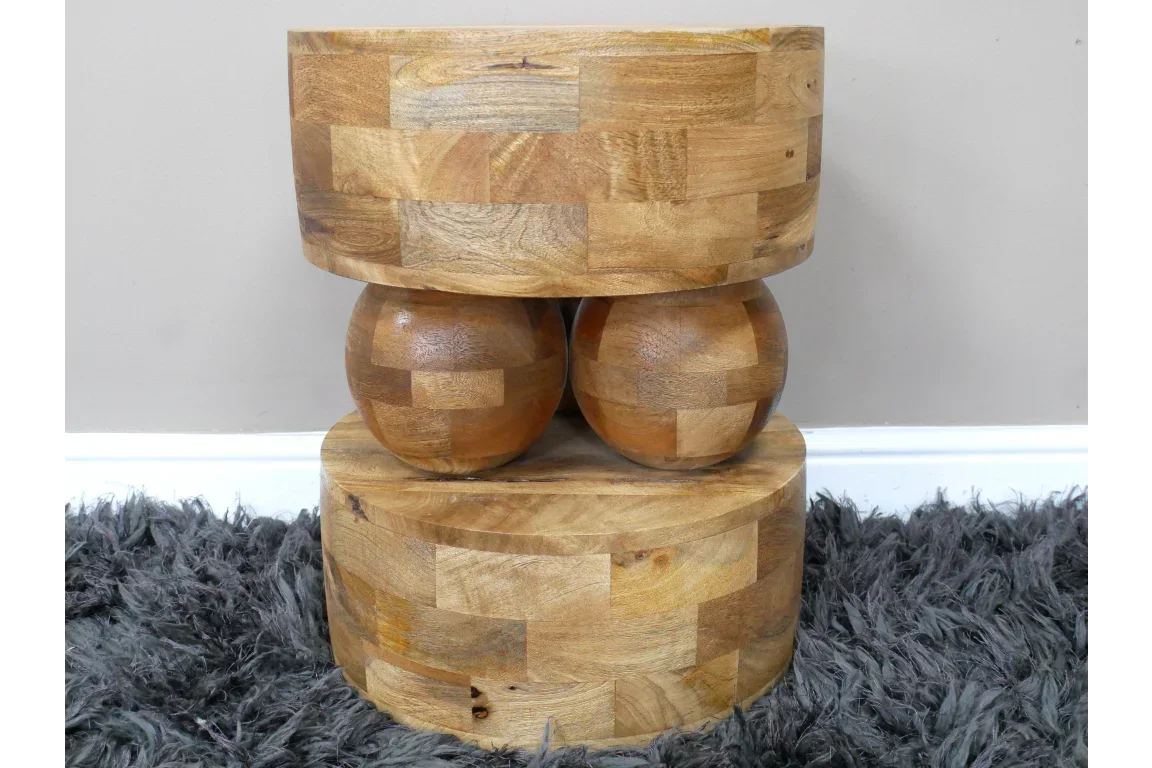 Chunky solid wood side table with geometric pattern on shaggy grey rug