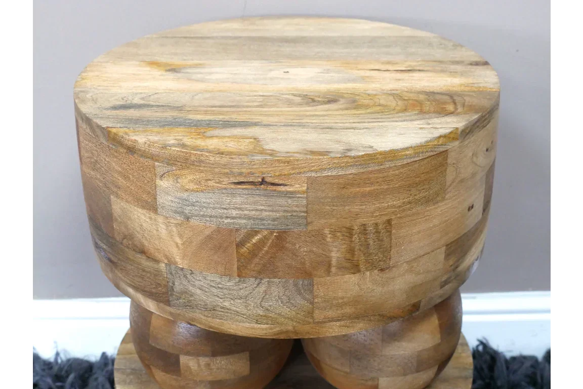 Round solid wood side table with natural grain and block pattern finish, close up view