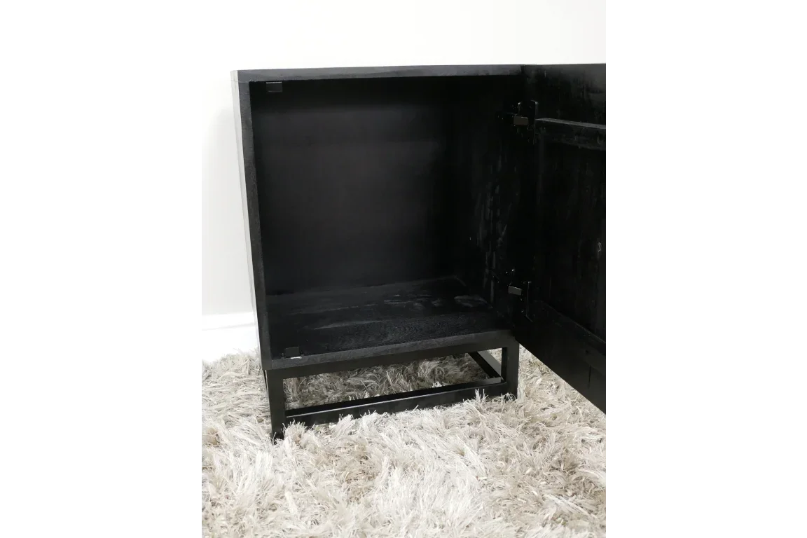 Black wooden cabinet with open door on plush beige rug, showing spacious interior storage
