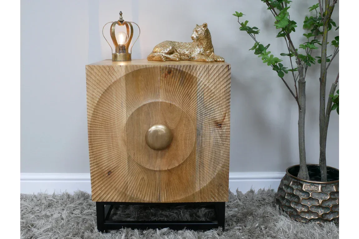 Wooden side table with circular carved front and gold knob on black metal legs