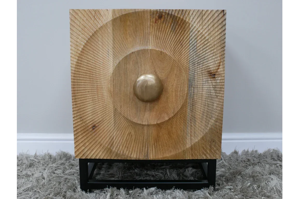 Square wooden side table with carved geometric pattern and metal base on grey rug