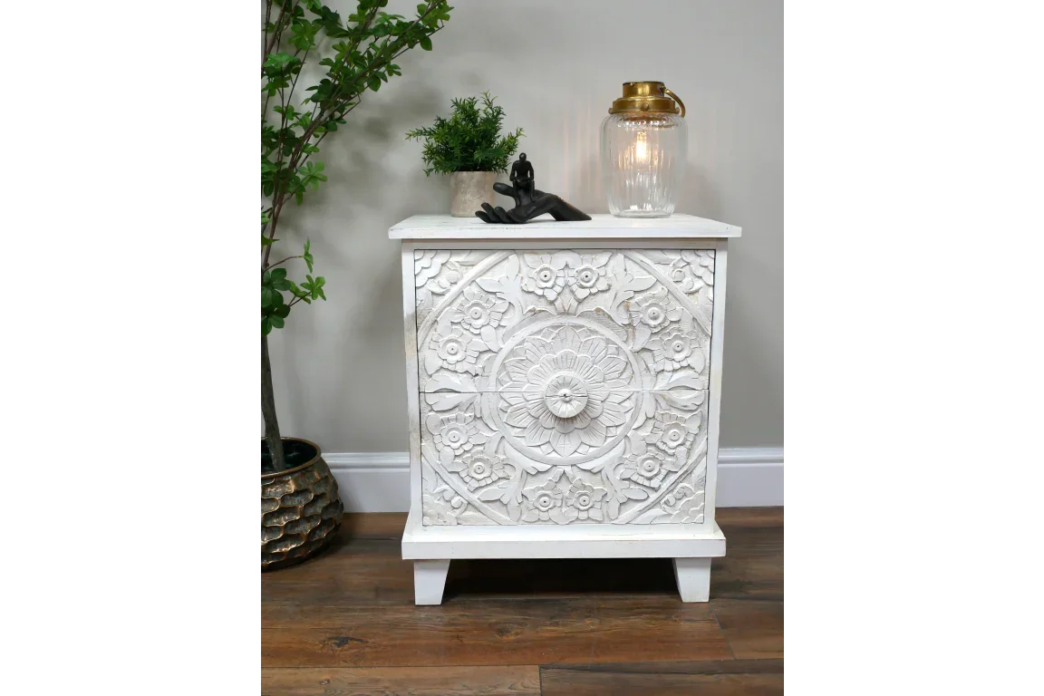 White carved wooden bedside cabinet with floral pattern on hardwood floor