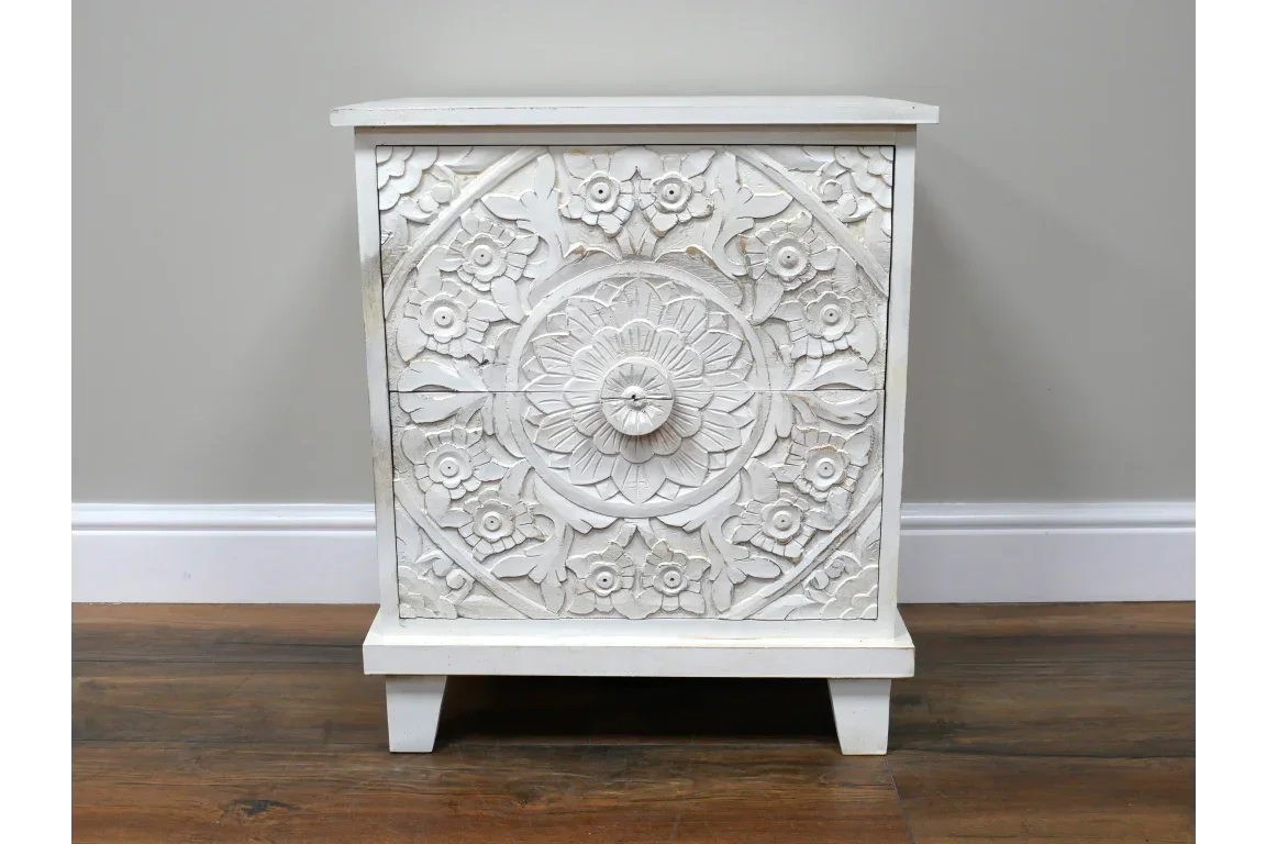 White carved wood bedside table with floral mandala detailing and two drawers