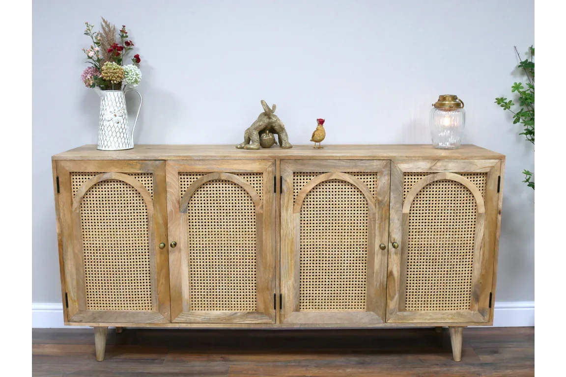 Natural wood sideboard with four cane doors and decorative items on top