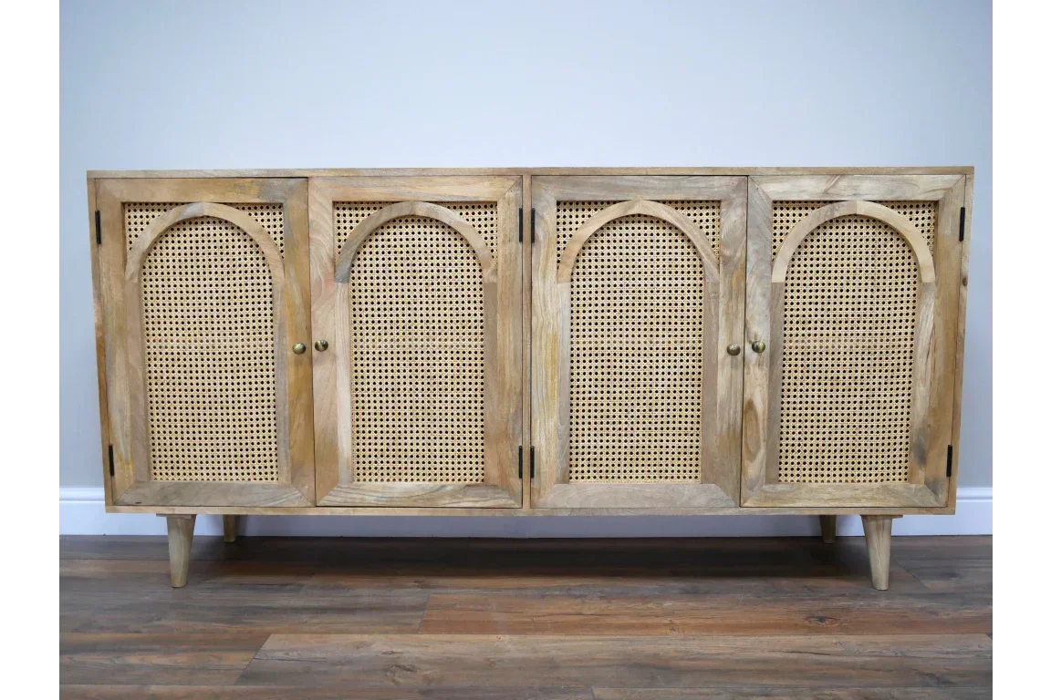 Light wood sideboard with four cane panel doors and arched detailing on hardwood floor