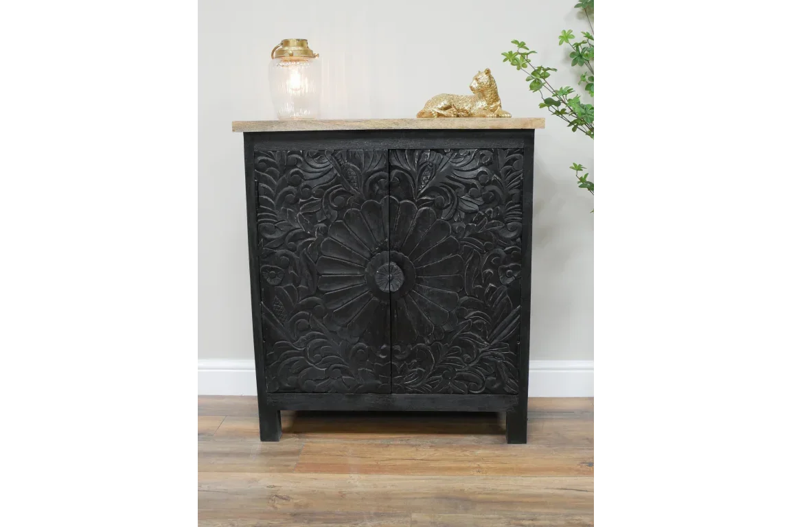 Black carved wood cabinet with floral patterns and natural wood top in room setting