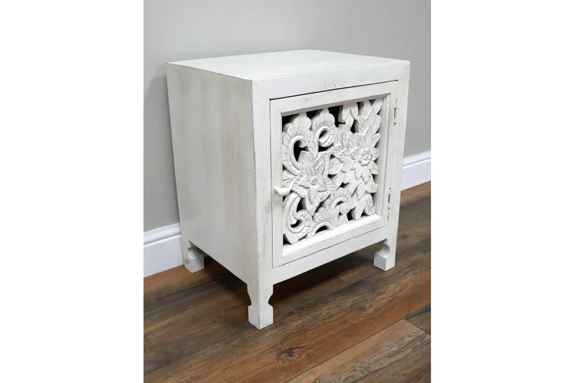 White wooden bedside cabinet with carved floral door on wood floor
