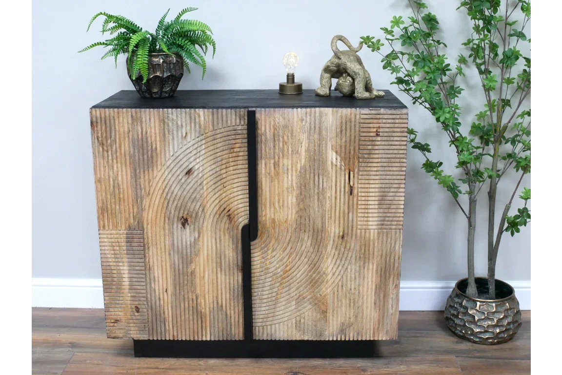 Wooden sideboard with carved geometric pattern, black top, and decorative items on surface