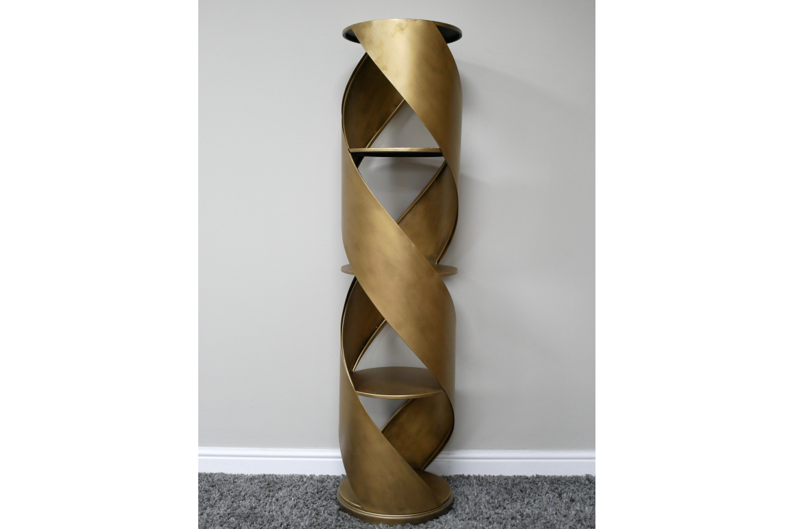 Tall gold metal display cabinet with spiral design and three shelves, shown from front on grey carpet background.