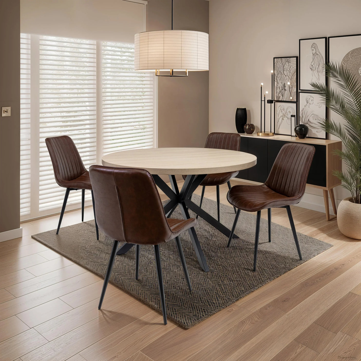 Round dining table with light wood top and four brown leather chairs on a rug