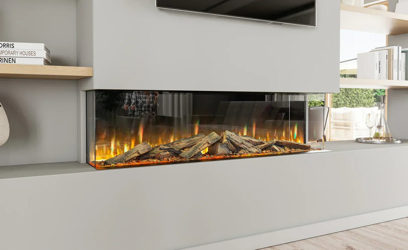 Modern electric fireplace with realistic log effect and glass sides built into living room wall
